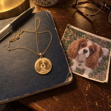 AI concept: Ruby’s gold Cavalier portrait necklace beside her matching photograph on a worn bedside notebook.